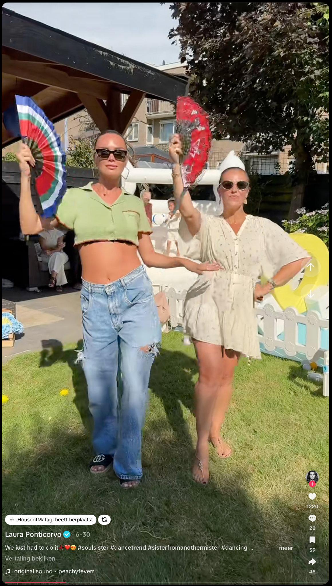 Two women in a sunny garden with MATAGI-inspired fan styling during a community moment